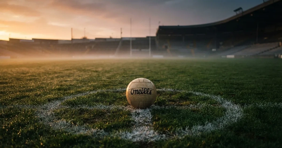 A ball on the centre spot of a grass pitch in morning light